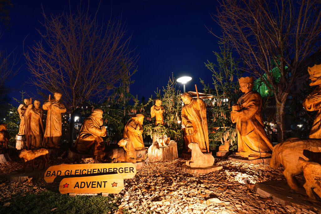 Handgeschnitzte Krippenfiguren beim Adventmarkt Bad Gleichenberg unter alten Bäumen.